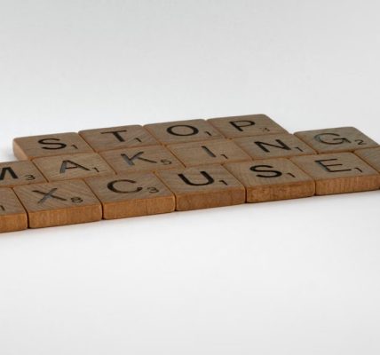 Inspirational phrase "Stop making excuses" crafted with wooden letter tiles.